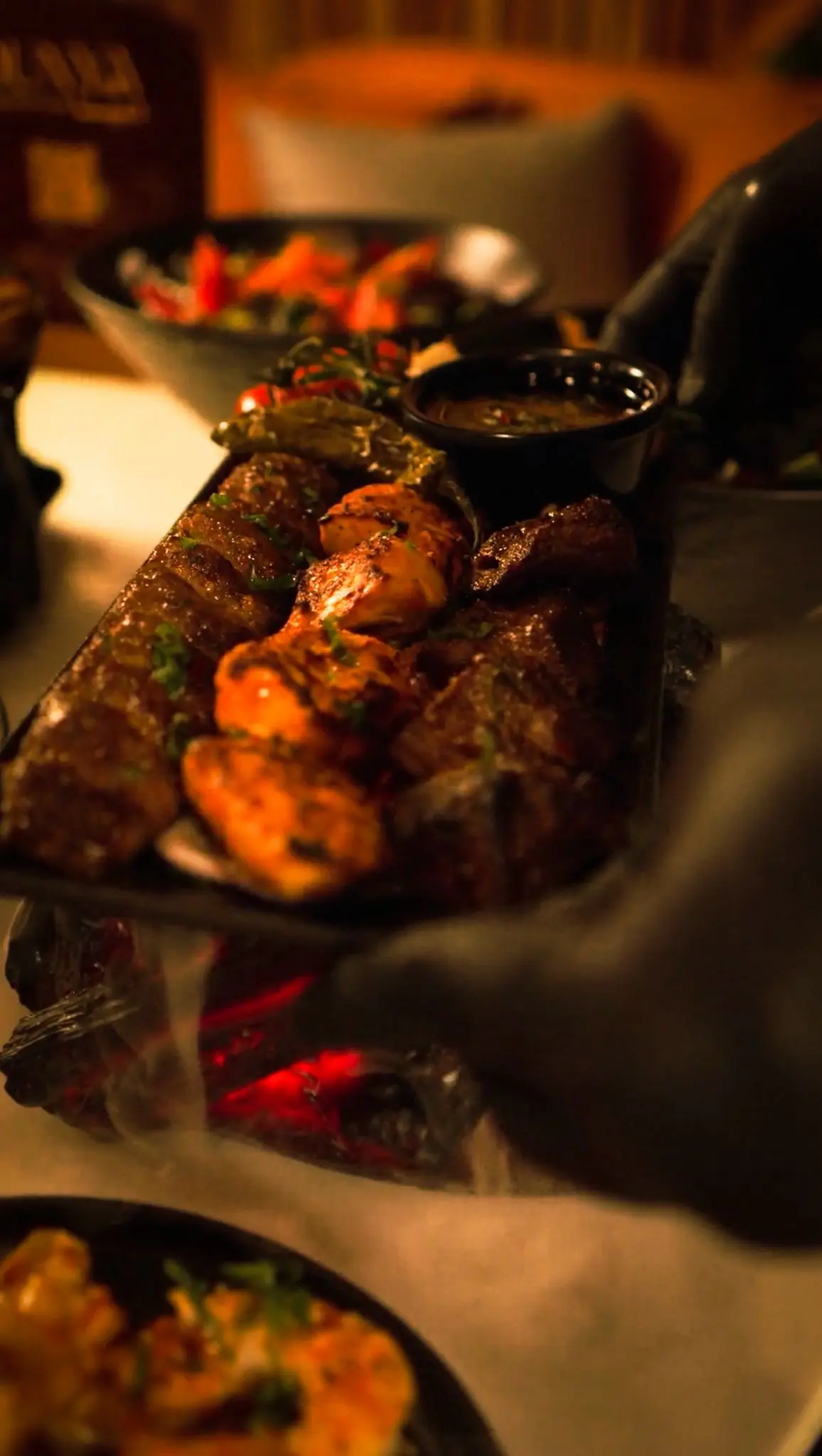 Grilled meat tray with lamb, chicken, and beef kafta served on a sizzling platter