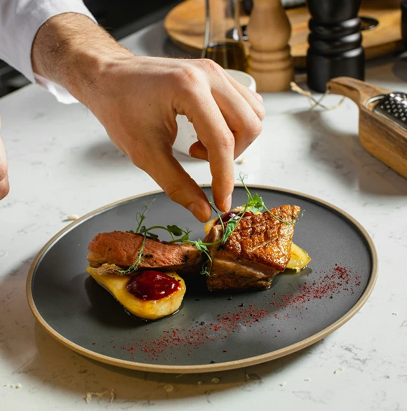 Chef plating a dish in the Dunya Lounge kitchen